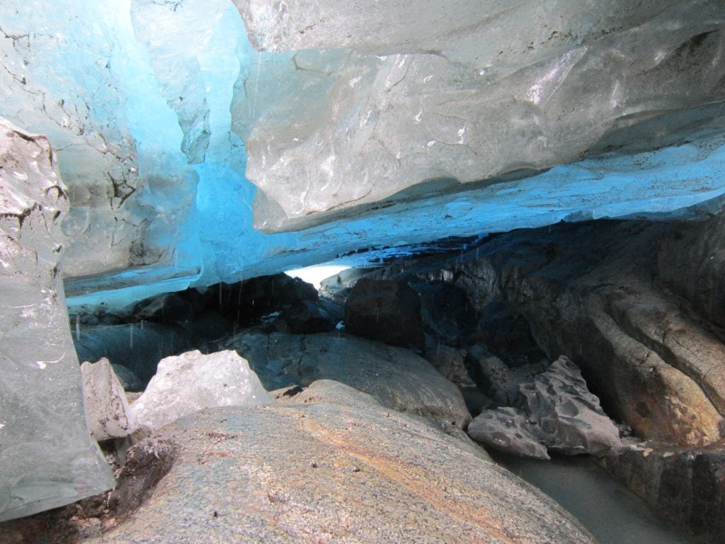 Entro a través de una pequeña grieta formada por grandes bloques sueltos, cruzo un pasadizo formado por hielo blanco hasta llegar a una gran cámara de hielo azul cobalto, el techo de hielo está bastante alto, gotea constantemente. A veces se oye un sonido bronco que resuena en medio de este silencioso lugar, es como si un leviatán moribundo gimiese el lugar no es nada seguro, año 2012.