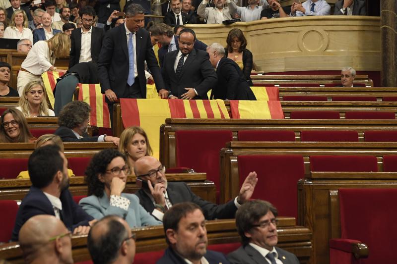 Deputies of the Partido Popular (PP) display Spanish flags as they leave the Catalan Parliament before the vote on a bill for a referendum on independence in Barcelona, on September 6, 2017. Catalonia's parliament passed a law on September 6, 2017 paving the way for an independence referendum on October 1 which is fiercely opposed by Madrid, setting a course for Spain's deepest political crises in decades. The law was adopted with 72 votes in favour and 11 abstentions. Lawmakers who oppose independence for the wealthy northeastern region of Spain abandoned the chamber before the vote. / AFP PHOTO / LLUIS GENE