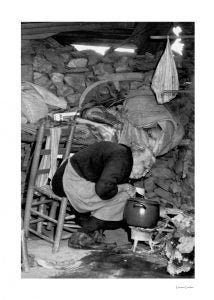 Mujer tratando de hacer la comida en una casa de piedra en la finca de la Casa de Alba en Zahínos.